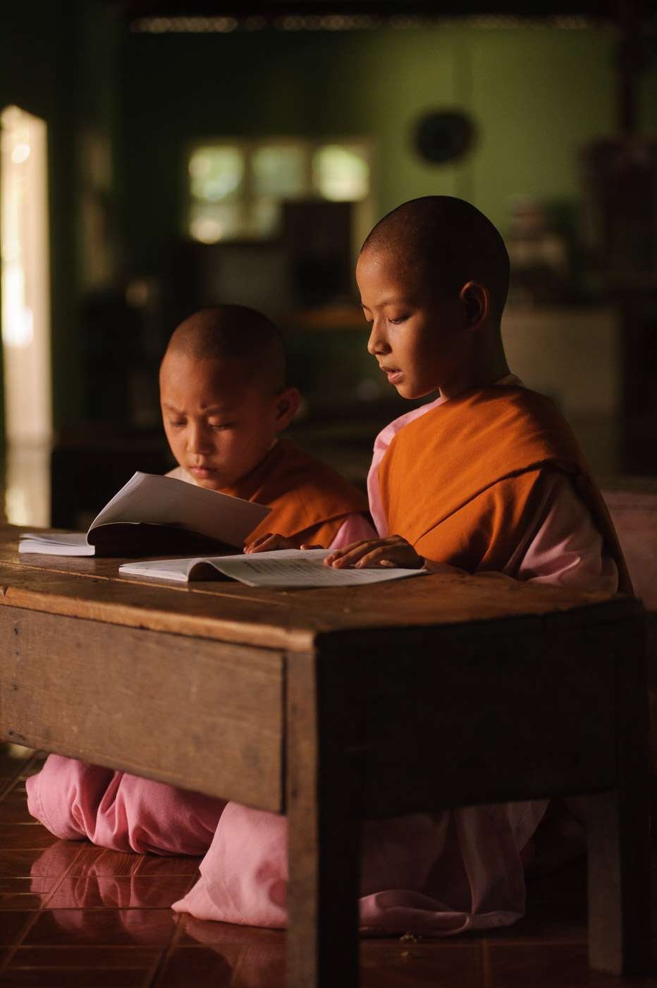 Tiny novitiate nuns study the Buddhist scriptures.