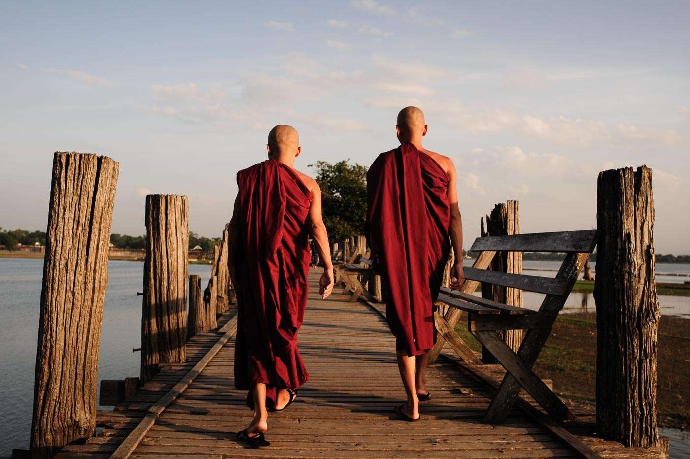 Monks stride over U Bein Bridge.