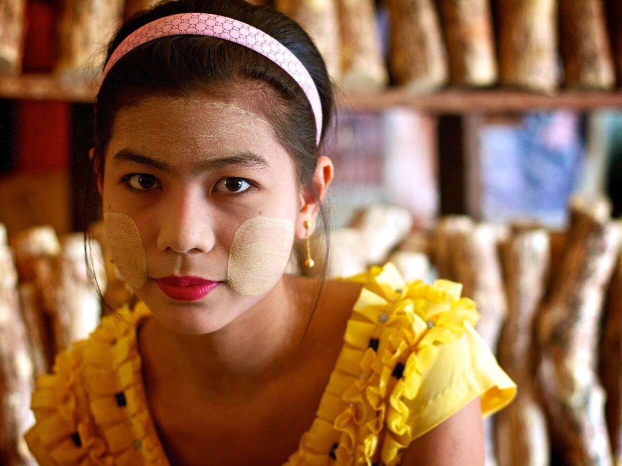 A Myanmar thanaka vendor models her own wares.